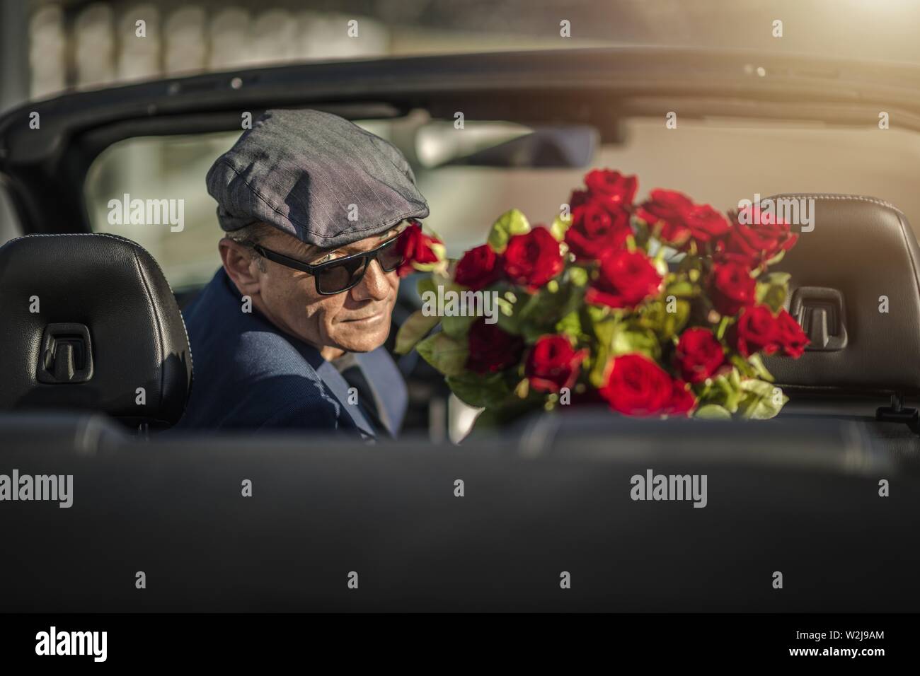 Sugar Daddy Augen Verführung. Attraktive kaukasische Männer mit Rosen  Warten auf seine Freundin in einem Cabrio Stockfotografie - Alamy