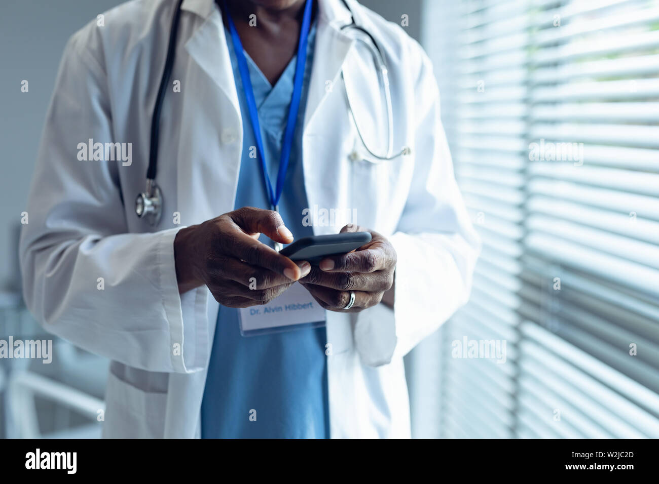 Männlichen Arzt mit Mobiltelefon im Krankenhaus Stockfoto