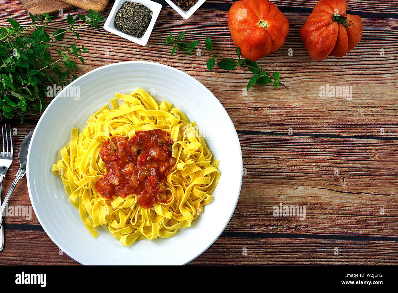 Hausgemachte Tagliatelle mit hausgemachter Sauce Ratatouille. Die Hälfte Pasta, frischen Tomaten, frische Eier, Knoblauch, Salz, Oregano, Pfeffer und Basilikum. Stockfoto