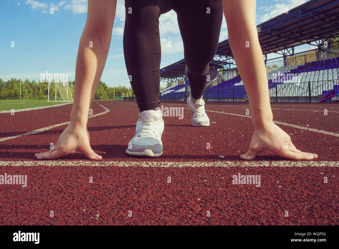 Athletische Jugendmädchen in der START-Stellung auf der Strecke. Konzept der vorwärts zu bewegen. Stockfoto