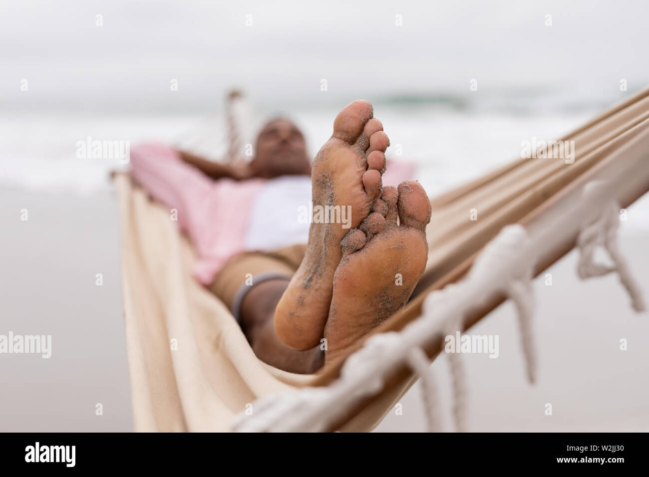 Mann schlafen mit den Händen hinter dem Kopf auf einer Hängematte Stockfoto