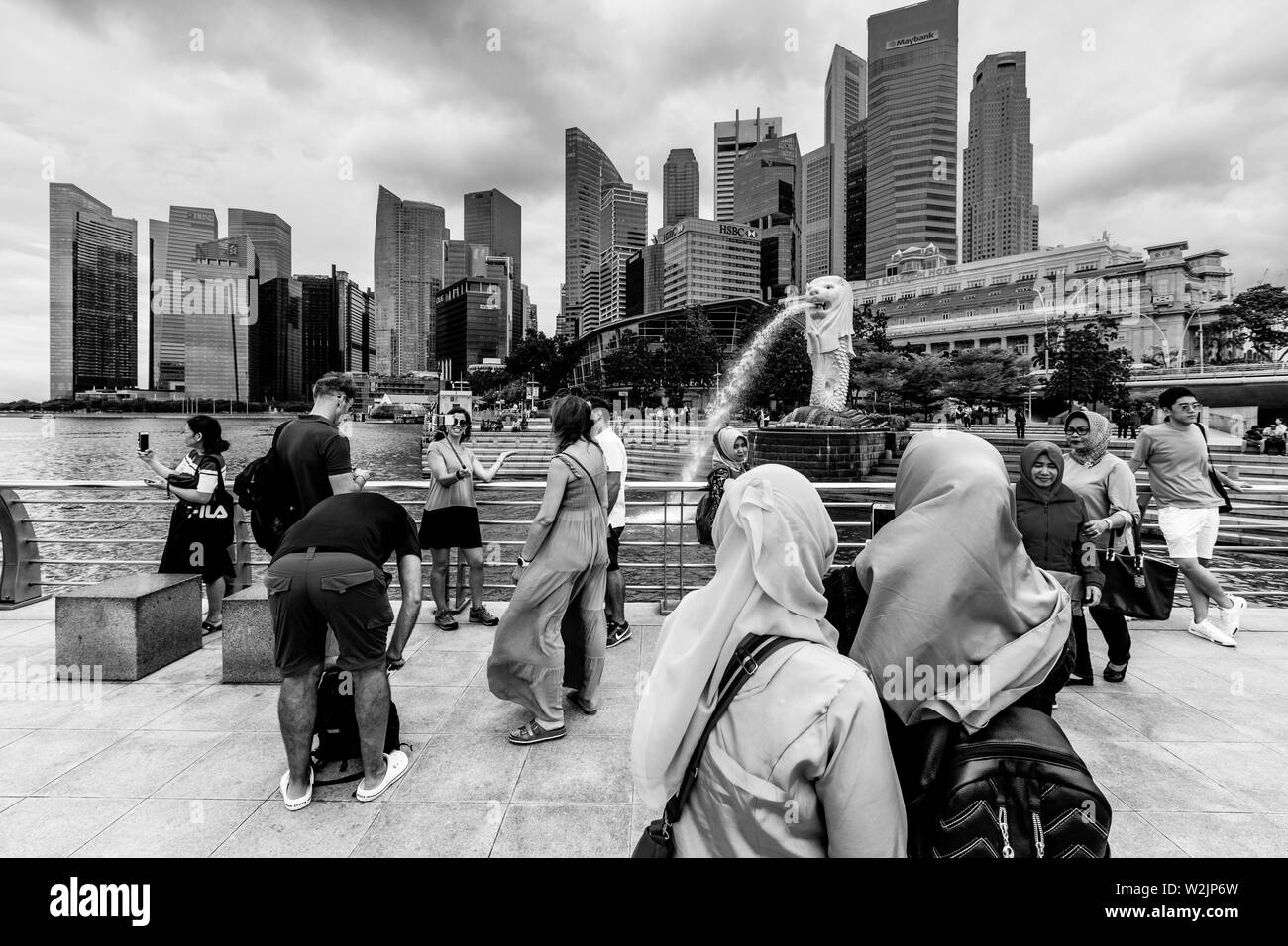 Touristen posieren für Fotos Vor dem Merlion Statue und die Skyline von Singapur, Singapur, Südostasien Stockfoto