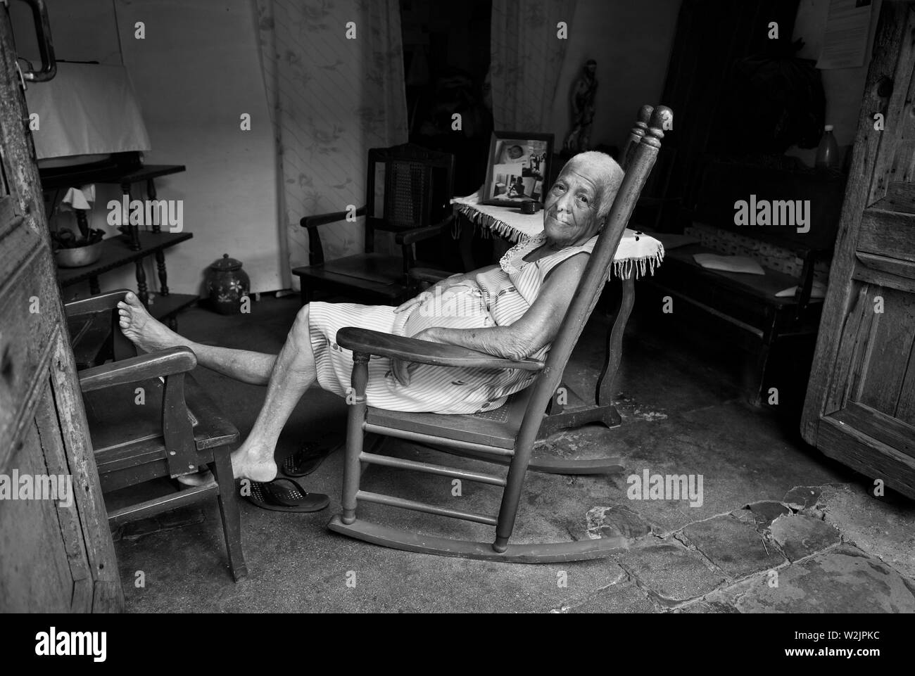 Trinidad Kuba: Die Dame ruht am Nachmittag in ihrem Schaukelstuhl, der darauf schaut, wie die Welt sie verpascht. Stockfoto