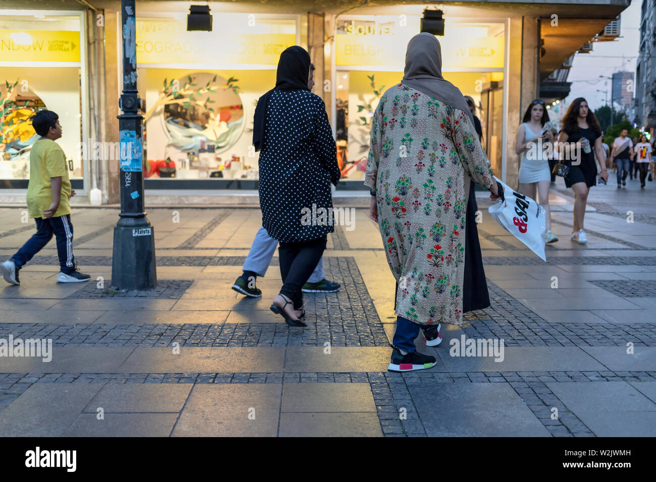 Belgrad, Serbien, 5. Juli 2019: städtische Szene mit einer kleinen Gruppe von iranischen Touristen zu Fuß den Knez Mihailova Straße in der Dämmerung Stockfoto