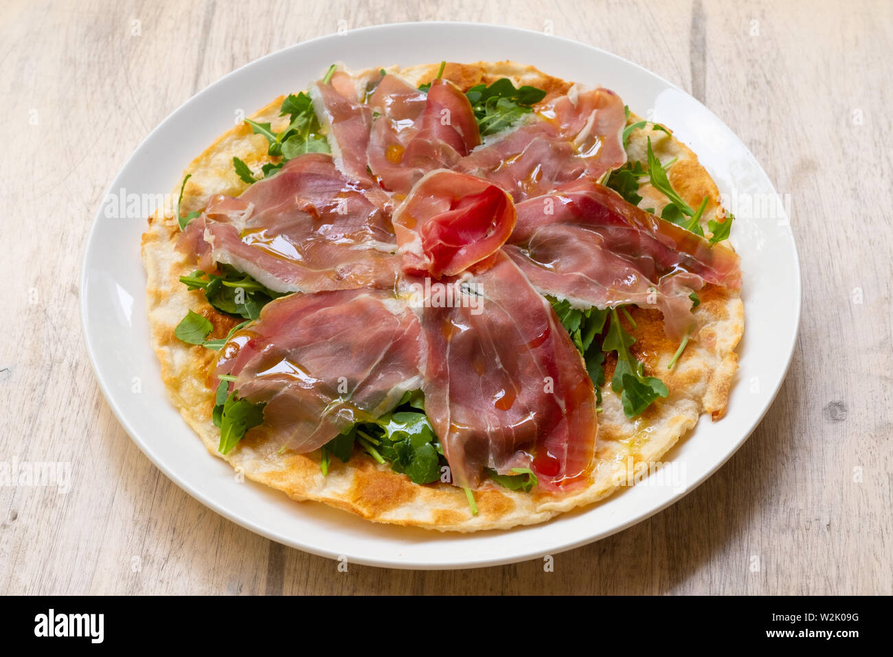 Focaccia di Recco traditionelle italienische Gericht aus der Region Ligurien, Genua, gefüllt mit stracchino Käse, Parmaschinken DOP, Rucola und Olivenöl Stockfoto