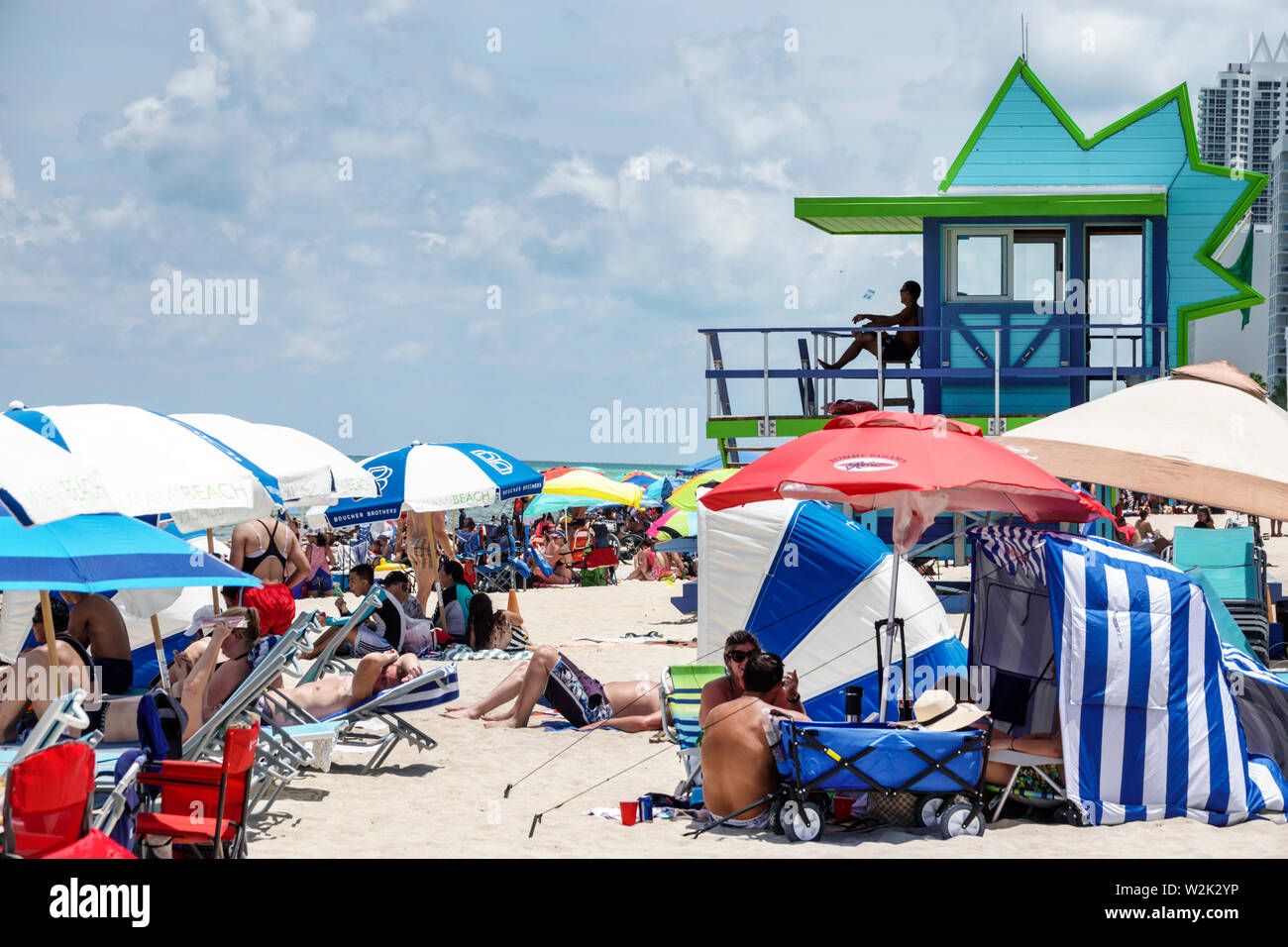 Miami Beach, Florida, North Beach, 4. Juli, überfüllter, überfüllter öffentlicher Strand, Sonnenschirme am Atlantischen Ozean, Familien, Sonnenbaden, Rettungsschwimmerstation, FL19070 Stockfoto