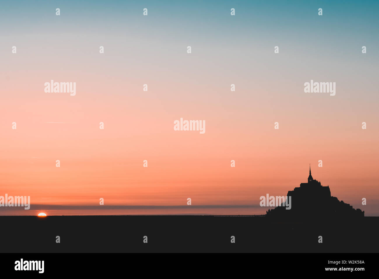 Schwarze Silhouette der Mont Saint Michel in einem orange und Teal sky Stockfoto