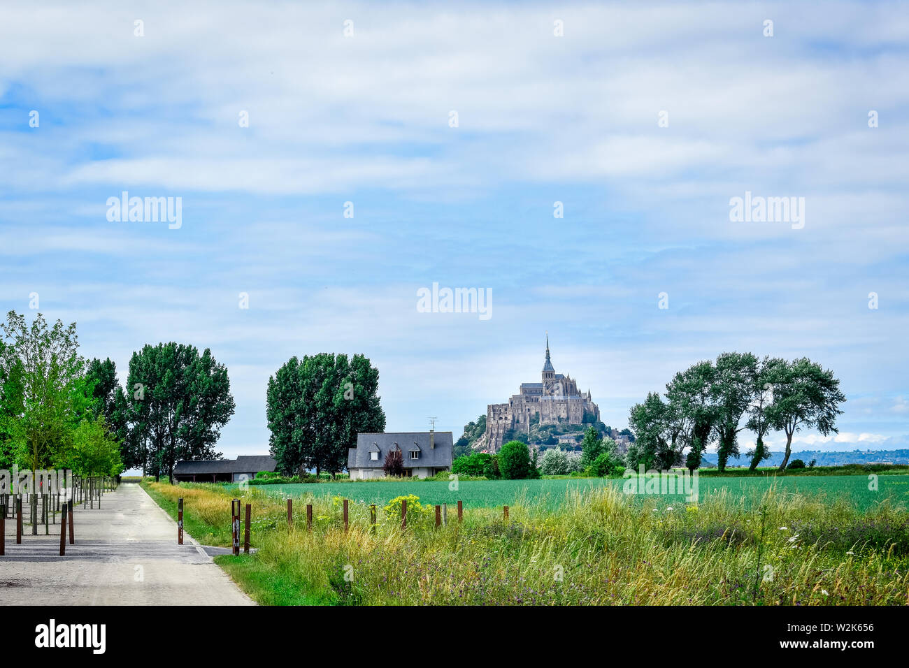 Allgemeine Ansicht von Mont Saint Michel, Frankreich. Pfad, Felder und Bäume. Blue Sky als Platz für Text. Stockfoto