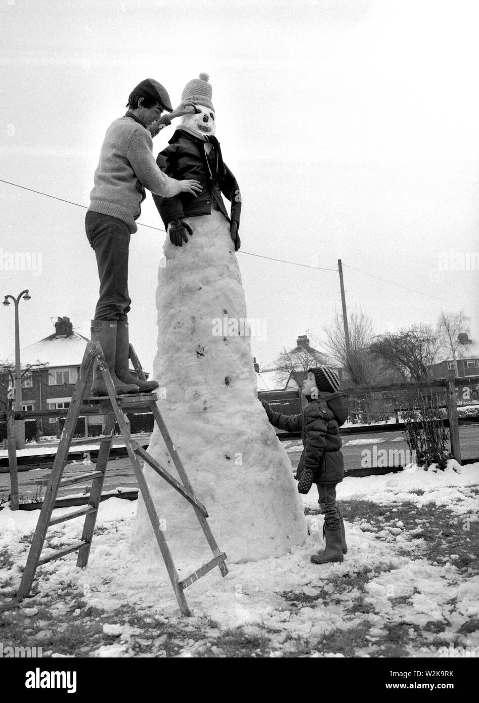 Vater und Sohn bauen eine riesige Schneemann in North Yorkshire 1985 Stockfoto