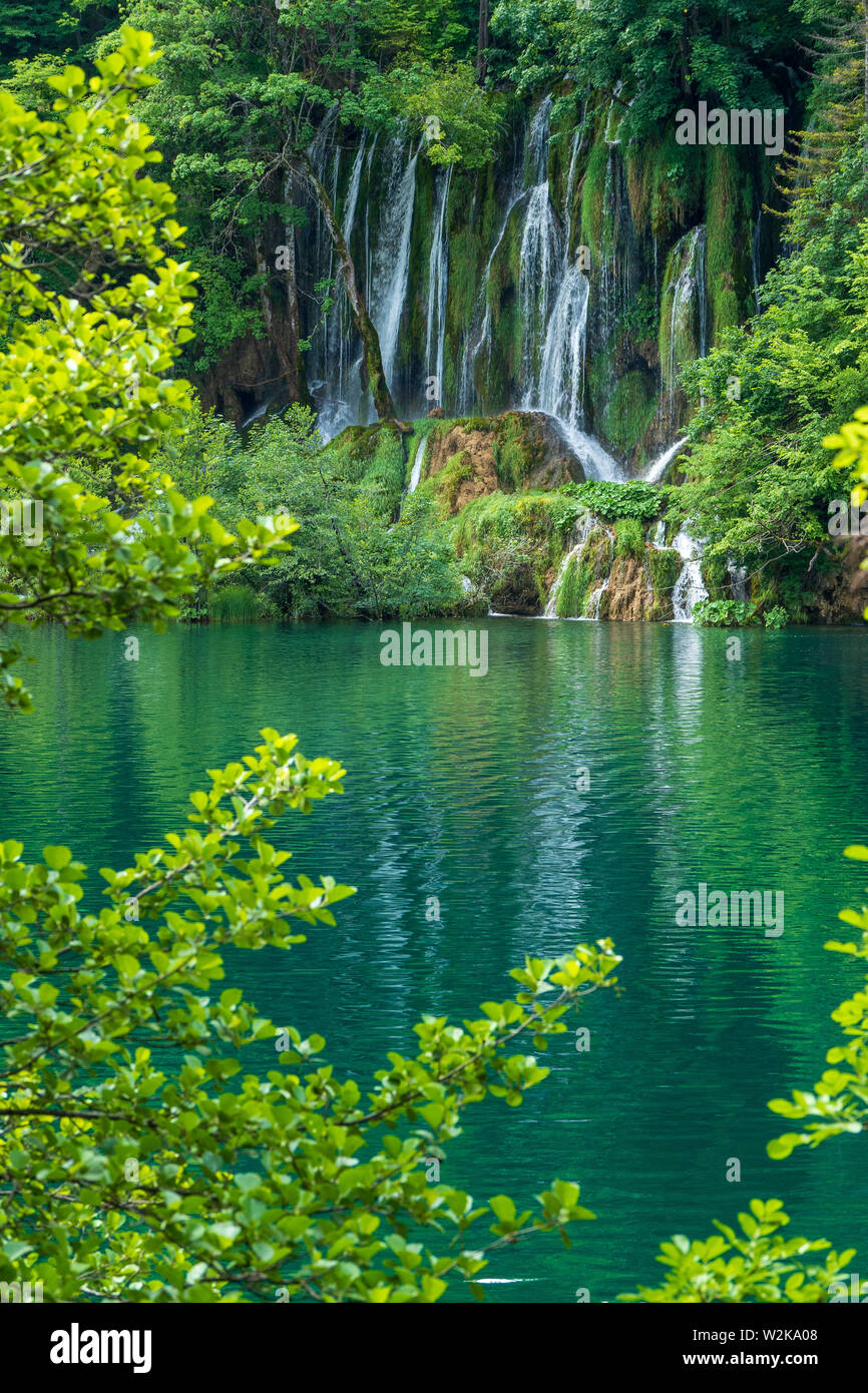 Kristallklares, reines Wasser, ausgegossen bemoosten Felsen in einem wunderschönen azurblauen See im Nationalpark Plitvicer Seen Plitvicer Seen, Kroatien Stockfoto