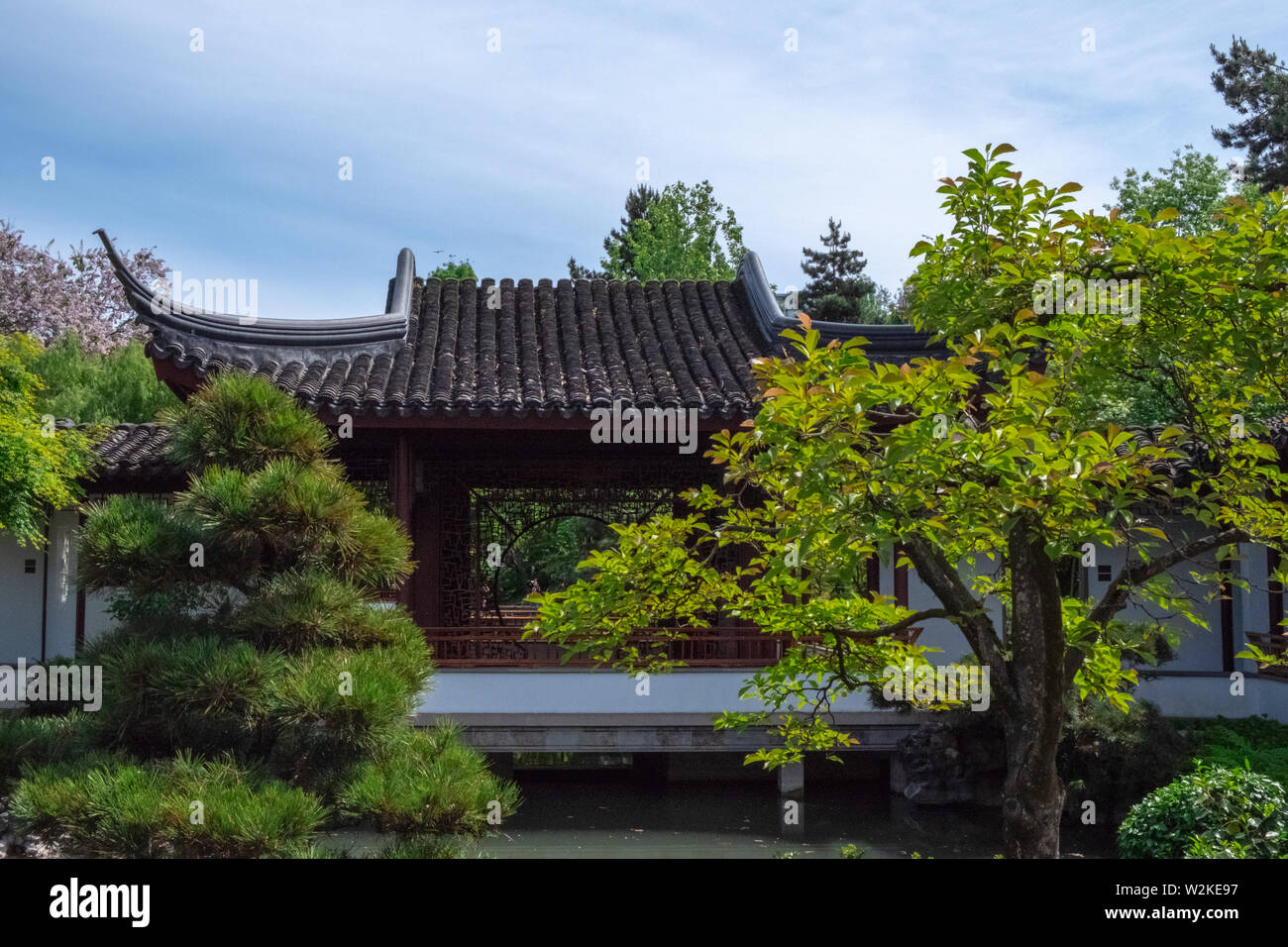 Dach eines traditionellen chinesischen Gebäude, durch Vegetation, an einem klaren, sonnigen Tag bei Dr. Sun Yat-Sen Classical Chinese Garden in Vancouver BC Umgeben Stockfoto