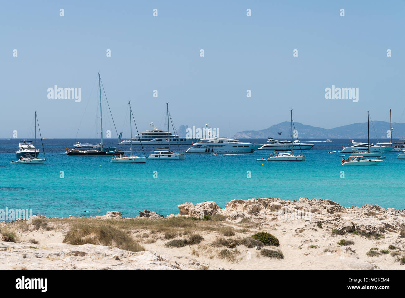 22.Juni 2019 - Formentera, Spanien. Vielen weißen moderne Yachten und Segelboote in der Nähe der Playa de Ses Illetes, türkisfarbenem Wasser Strand. Stockfoto