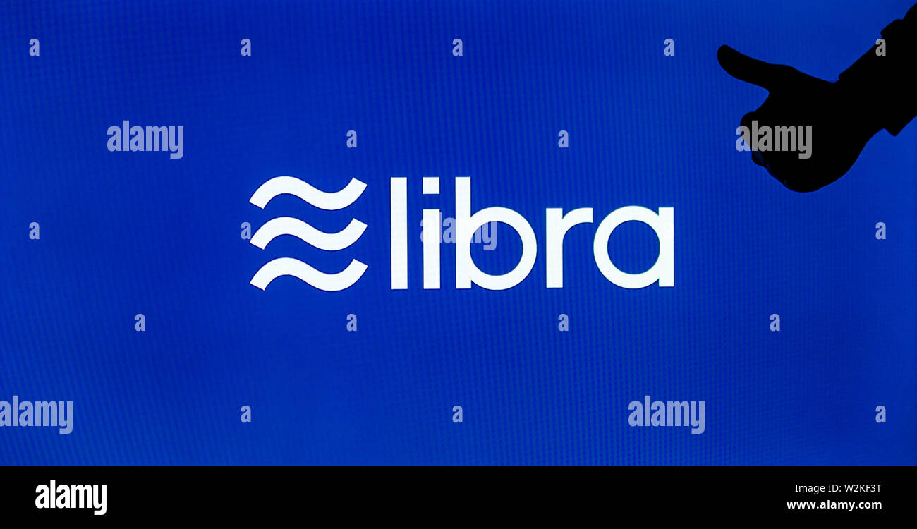 Facebook Waage cryptocurrency Logo auf dem Bildschirm angezeigt und die Silhouette von Mag. Konzeptuelle Wahrnehmung einer neuen Währung zu reflektieren. Stockfoto