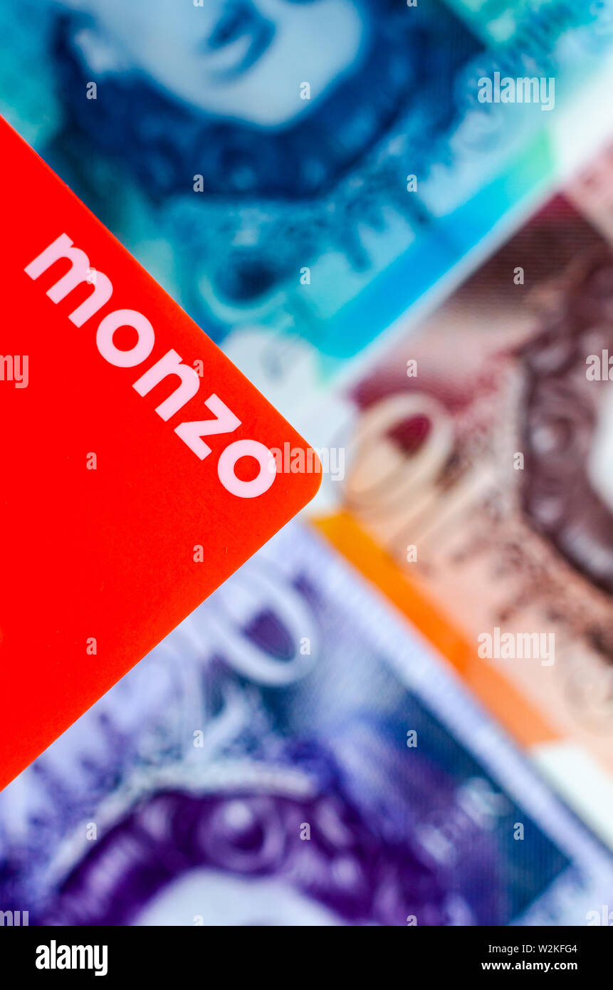 Monzo bank karte auf den verschwommenen Hintergrund der britischen Cash verschiedenen Konfessionen. Stockfoto