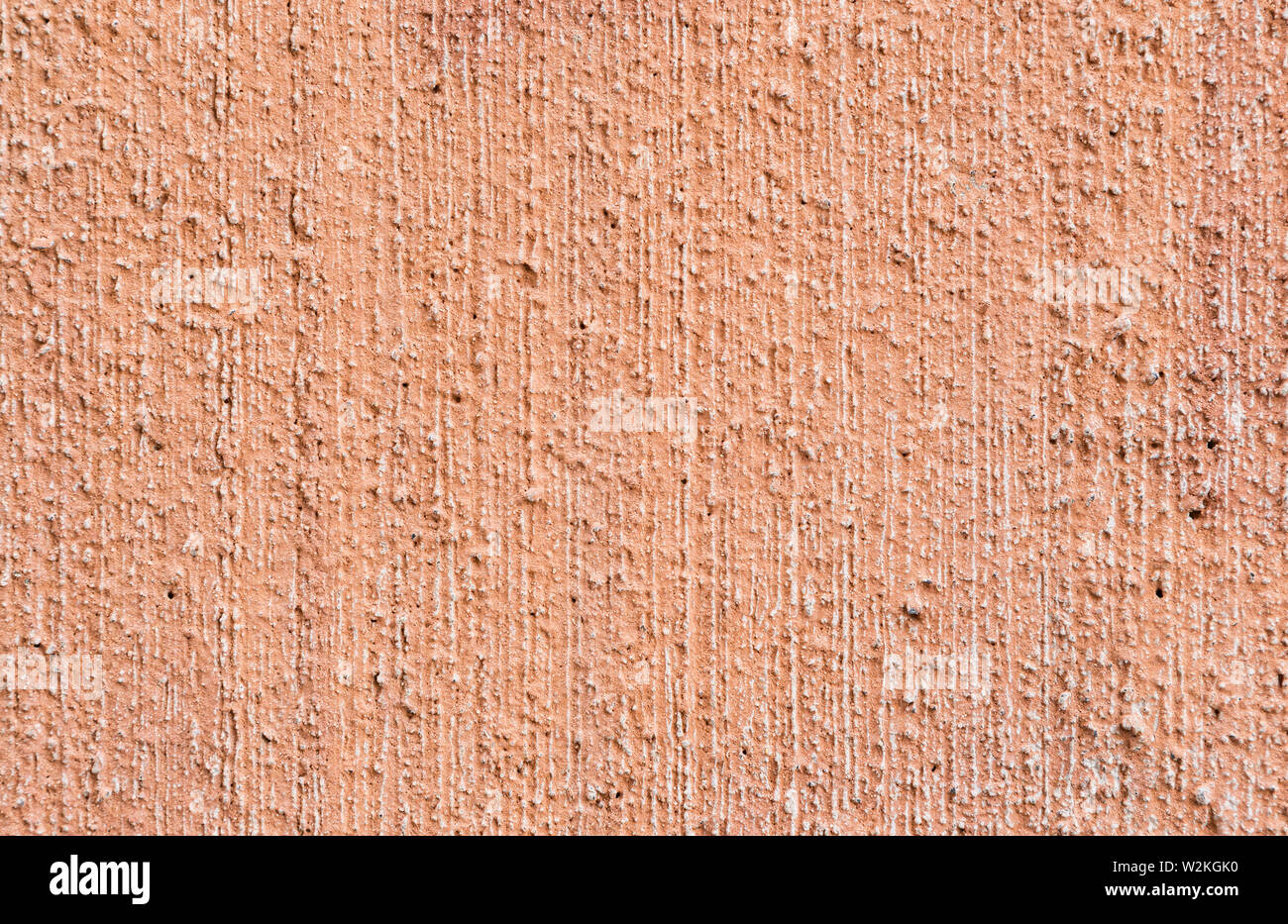 Makro Nahaufnahme der verputzt, lackiert, verblasst, rauh und Rot, Orange oder Pfirsich Beton oder Stein Wand. Hochauflösende full frame strukturierten Hintergrund. Stockfoto