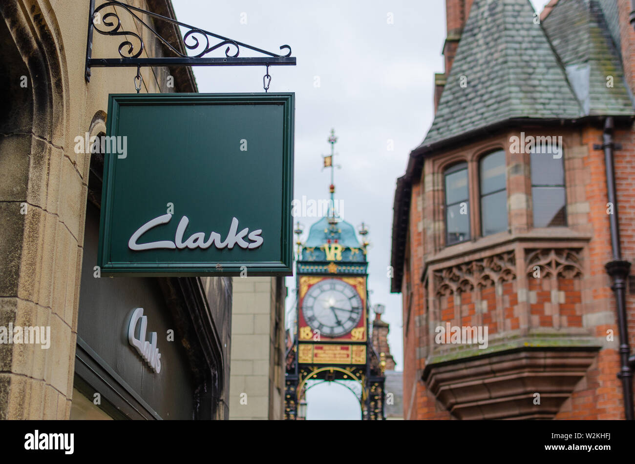 Clarks Shop anmelden und die berühmte Chester Eastgate Clock im Hintergrund. Die High Street, Chester, Vereinigtes Königreich. Stockfoto