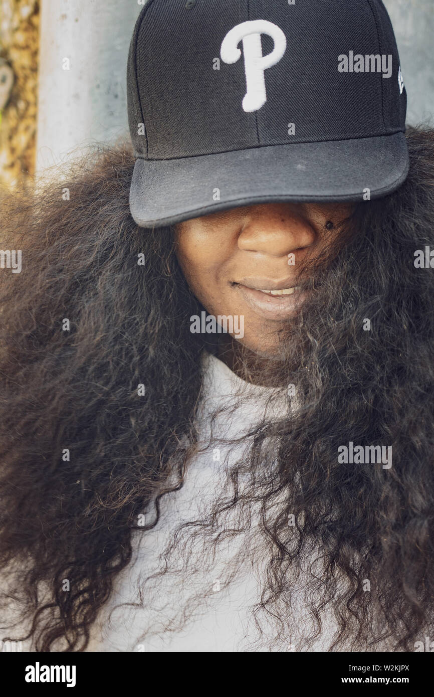 Erwachsene afrikanische amerikanische Frau trägt ein Phillies cap Lächeln für ein Portrait Stockfoto