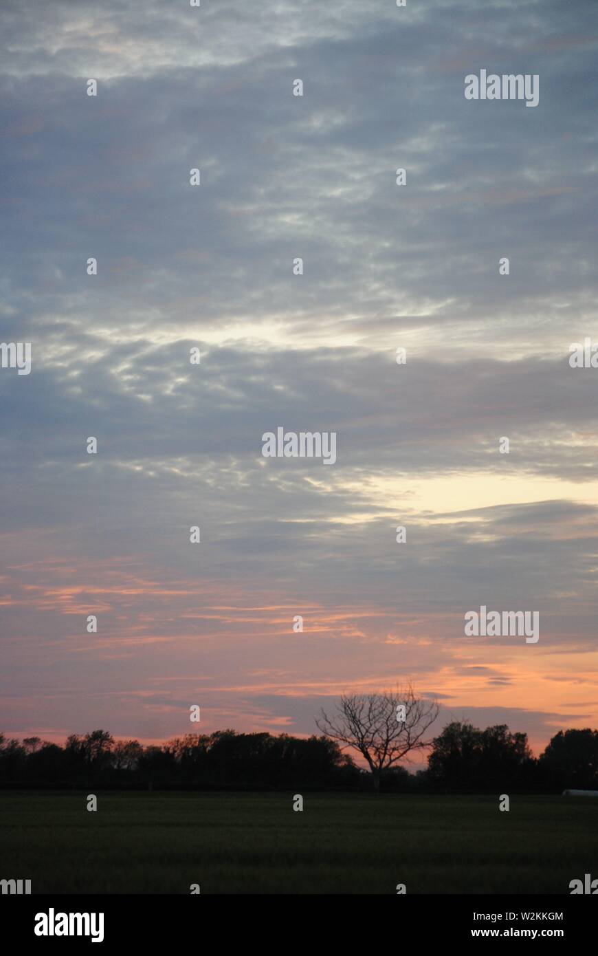 Ein Sonnenuntergang mit einer dünnen Wolkenschicht am Himmel Stockfoto