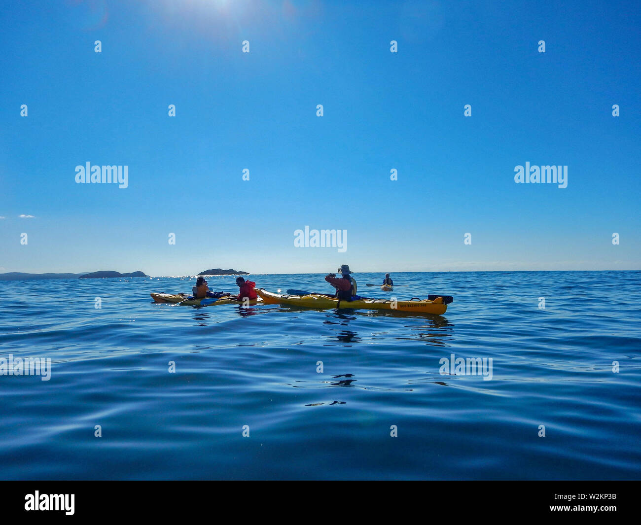 Vier Personen am Ocean Kayak Tour an einem sonnigen Wintertag, Batemans Bay, Australien Stockfoto