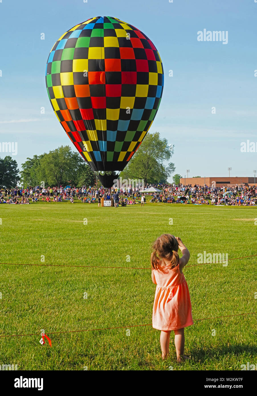 Kleines Mädchen winken zu Heißluftballon über aufzusteigen. Stockfoto