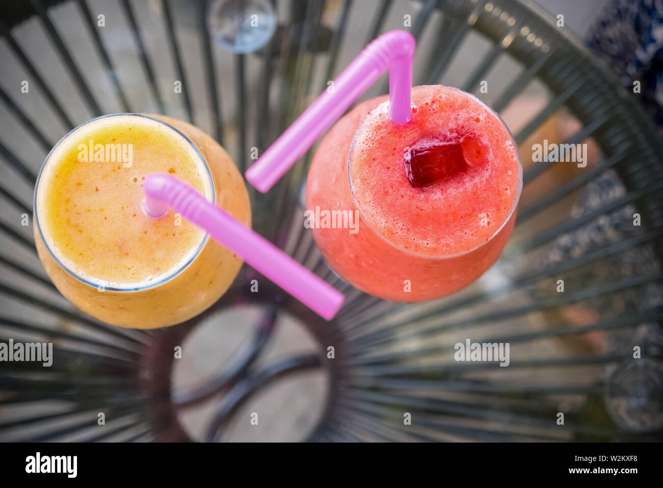 Frisch gemischt Smoothies in verschiedenen Farben und Geschmacksrichtungen, die in Gläsern. Frischer Saft Gelb, Rot. Saft trinken im Freien. Sommer Getränke für Kinder Stockfoto