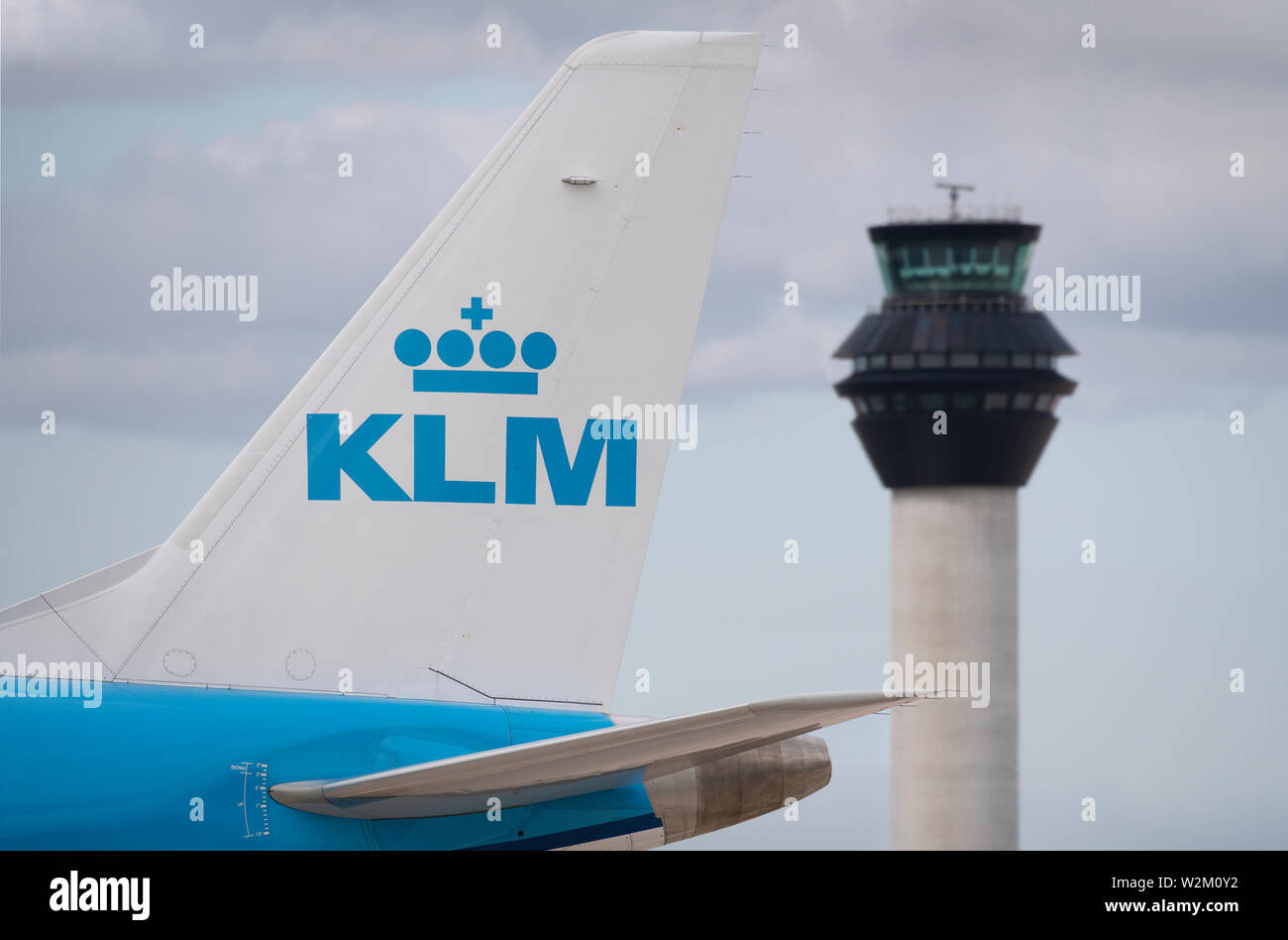 Die heckflosse eines KLM Airliner entlang der Start- und Landebahn vor dem Kontrollturm am Flughafen Manchester rollen. Stockfoto