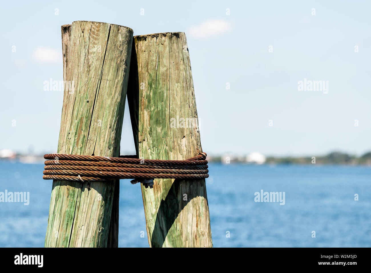 Nahaufnahme der Anker Holz- Poller auf dem Boot Pier in Fort Myers Florida mit Bucht von Blue Water Stockfoto