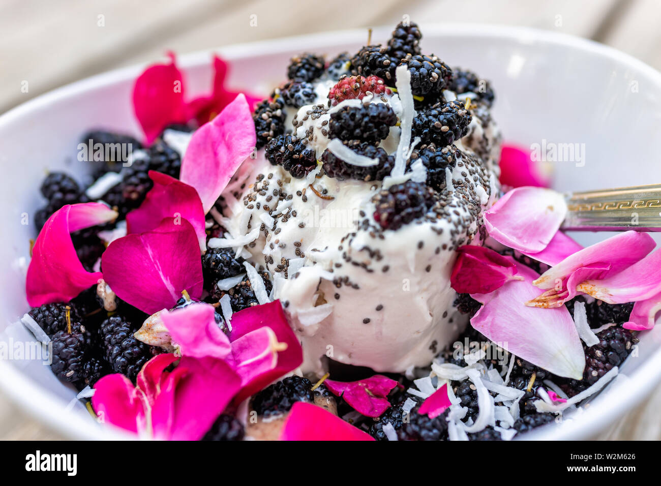 Rosenblätter blumen Eis garniert mit frischen schwarzen Maulbeeren Beeren und Chia Samen in der Schüssel mit Löffel closeup Stockfoto