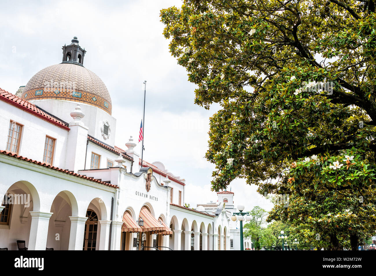 Hot Springs, USA - Juni 4, 2019: Historische Quapaw Bäder Whirlpool Haus mit amerikanischer Flagge und Kuppel von vielen Magnolia südlichen Bäume in der Stadt Stockfoto