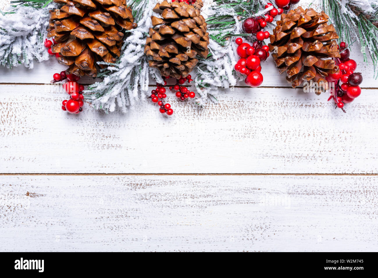 Weihnachtsschmuck auf weißem Holz Hintergrund mit kopieren. Tannenzapfen, Garland, Beeren und Kiefer Niederlassungen Stockfoto