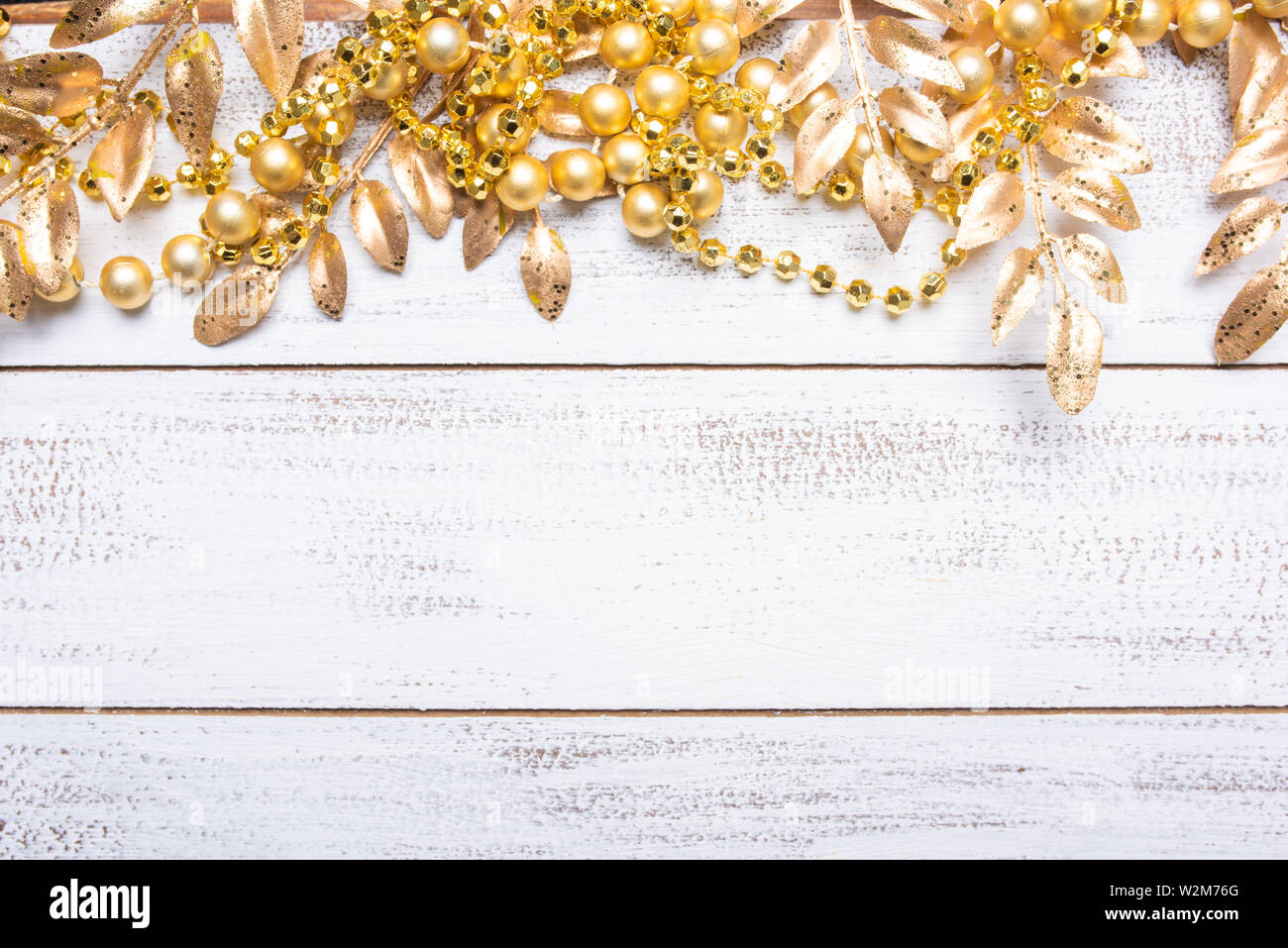 Goldfarbenen Weihnachtsschmuck auf weißem Holz Hintergrund mit kopieren. Blätter, Girlande, Beeren etc. Stockfoto