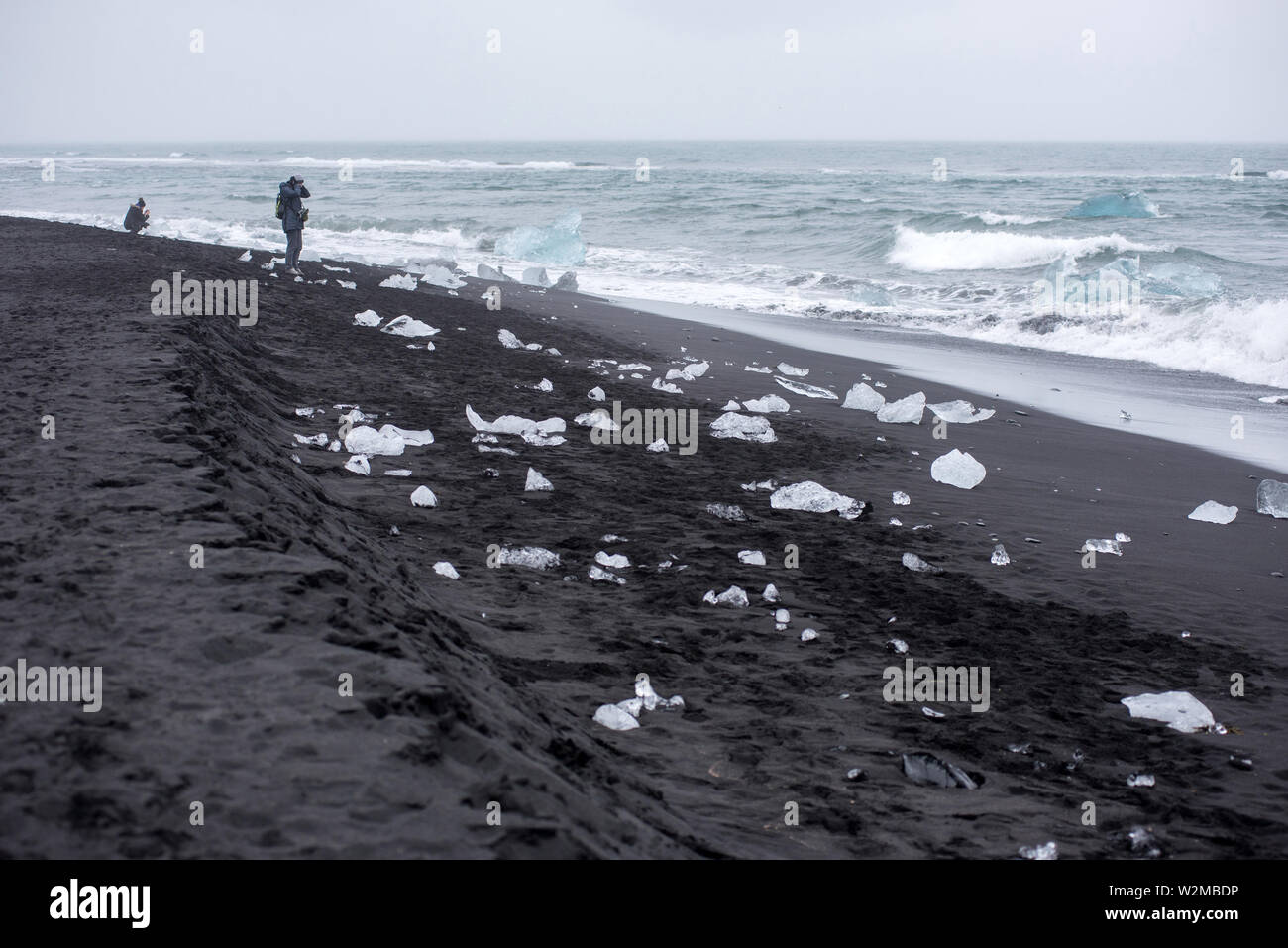 DIAMOND BEACH, JOKULSARLON, ISLAND - 22. MAI 2019: Touristen bewundern und Fotografieren der schmelzenden Eisbergen auf dem Atlantik Küste in Jokulsarlo Stockfoto