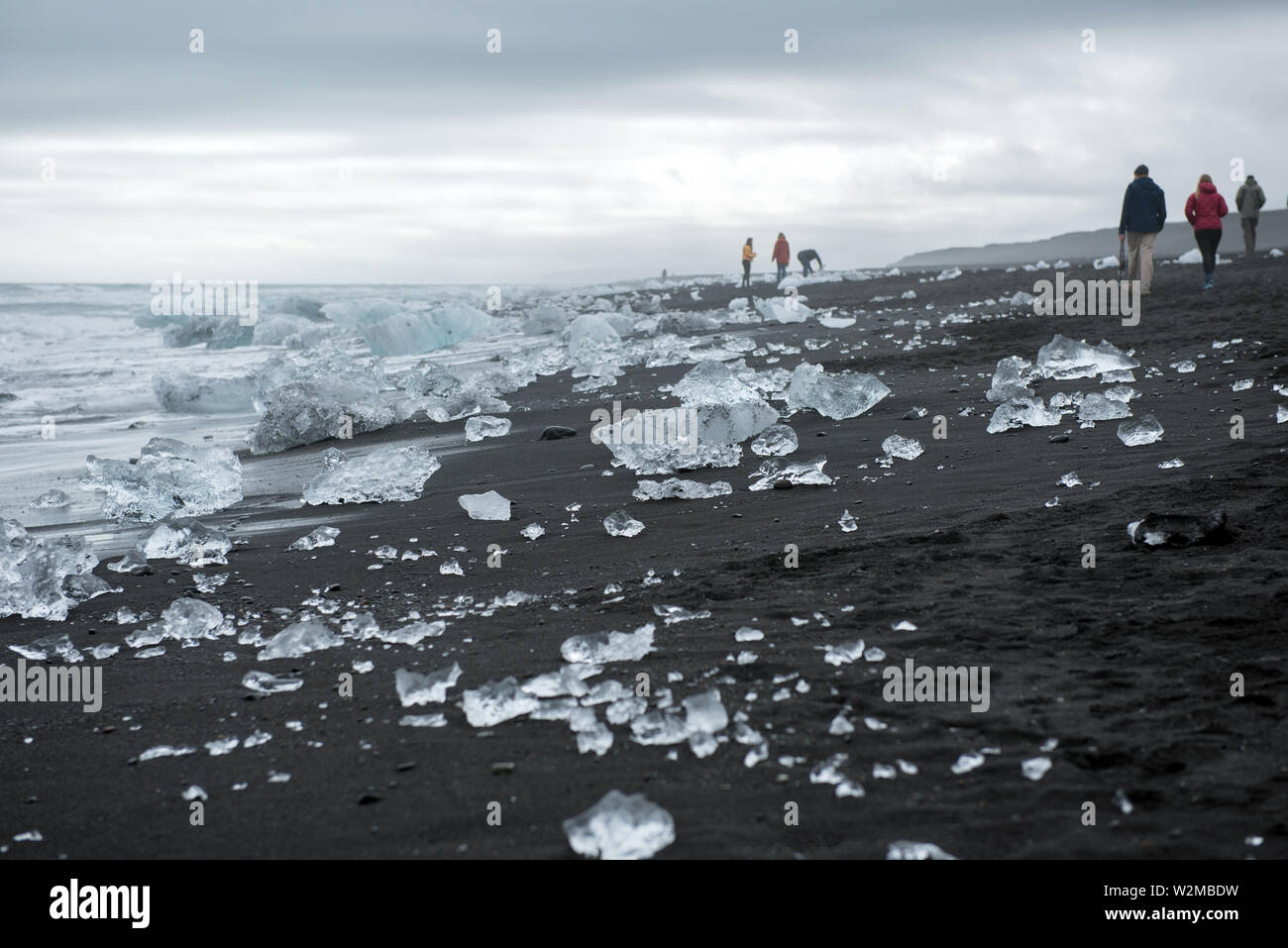 DIAMOND BEACH, JOKULSARLON, ISLAND - 22. MAI 2019: Touristen bewundern und Fotografieren der schmelzenden Eisbergen auf dem Atlantik Küste in Jokulsarlo Stockfoto
