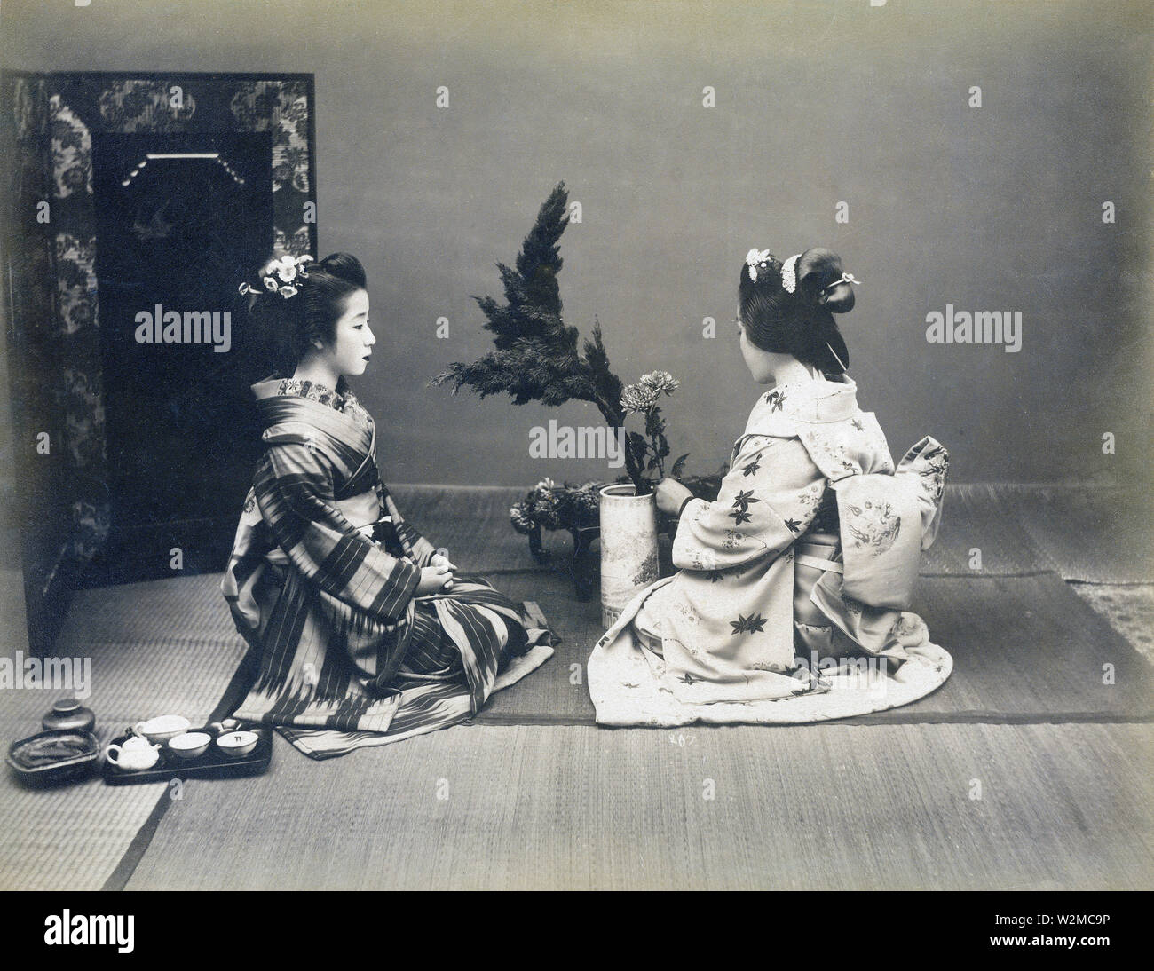 [1880s Japan - Japanische Frauen üben Ikebana Flower Arrangement] - zwei Frauen im Kimono und traditionellen Frisuren üben Ikebana Flower Arrangement. 19 Vintage albumen Foto. Stockfoto