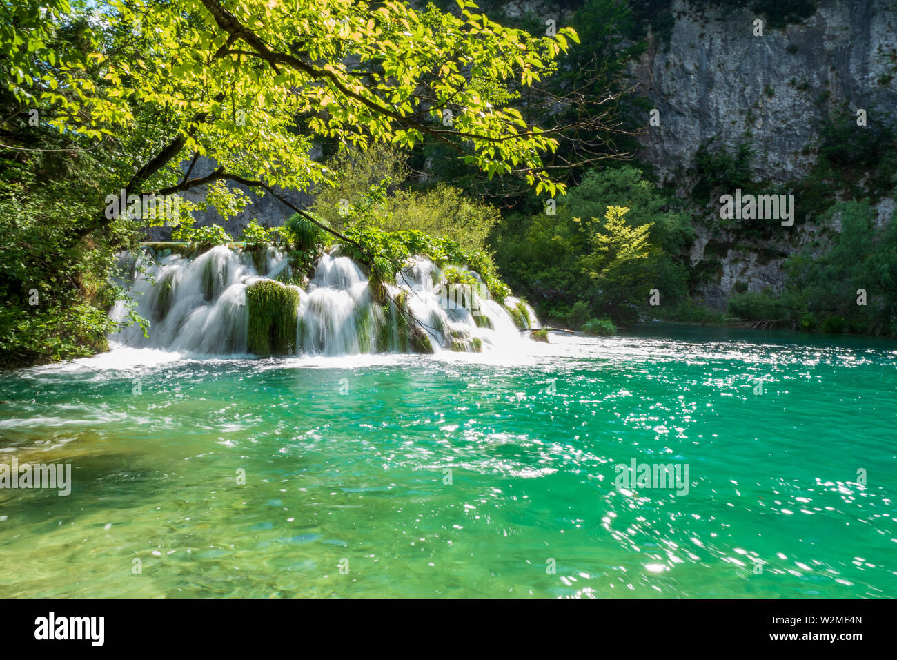 Rauschende Wasserfälle, die natürliche Hindernisse in den glasklaren und azurblauen See Gavanovac im Nationalpark Plitvicer Seen, Kroatien Stockfoto