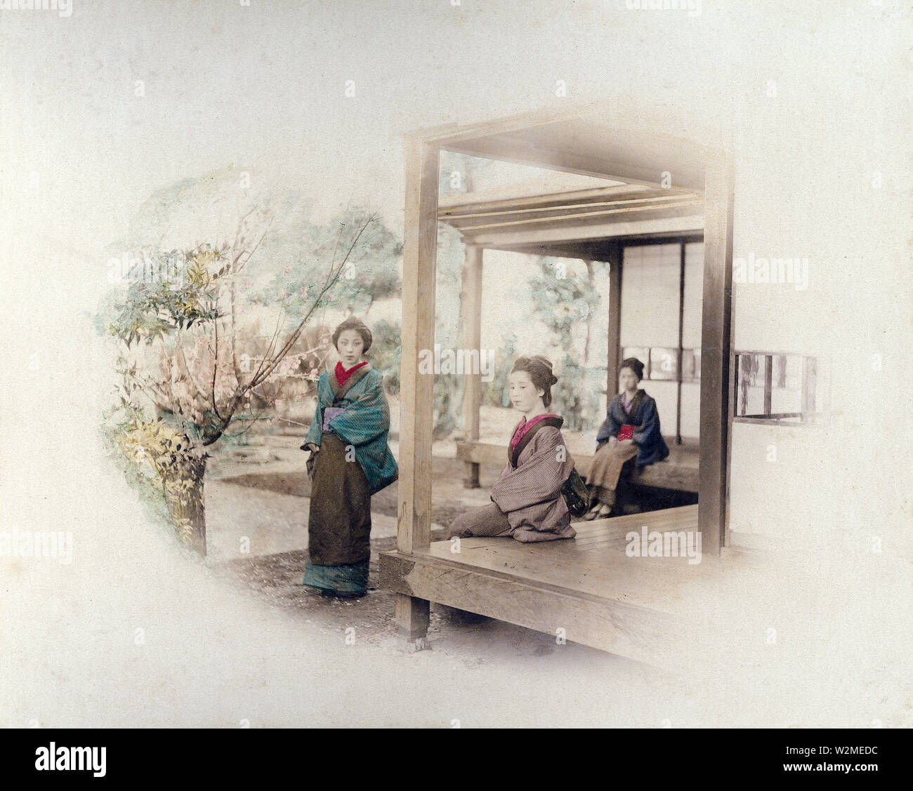 [1880s Japan - Drei japanische Frauen in einem Wohngebiet Veranda] - Drei Frauen im Kimono und traditionellen Frisuren in einem traditionellen japanischen Haus, 1880. Zwei Frauen sitzen auf der engawa, eine Veranda - wie Erweiterung des Hauses. 19 Vintage albumen Foto. Stockfoto