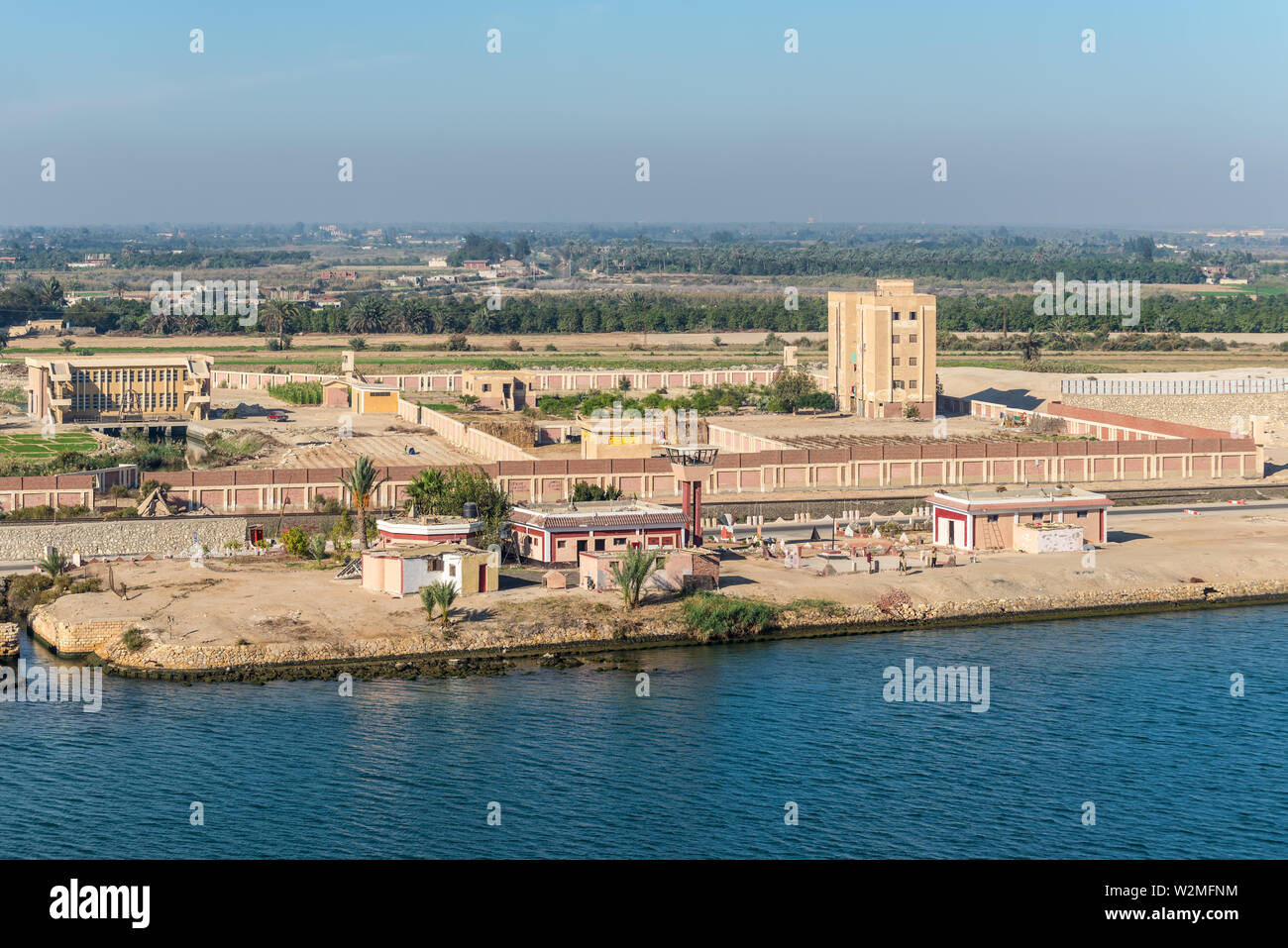 El Qantara, Ägypten - November 5, 2017: Gebäude und Felder am Ufer des Suez Kanal in der Nähe von El Qantara, Ägypten. Typische Landschaft. Stockfoto