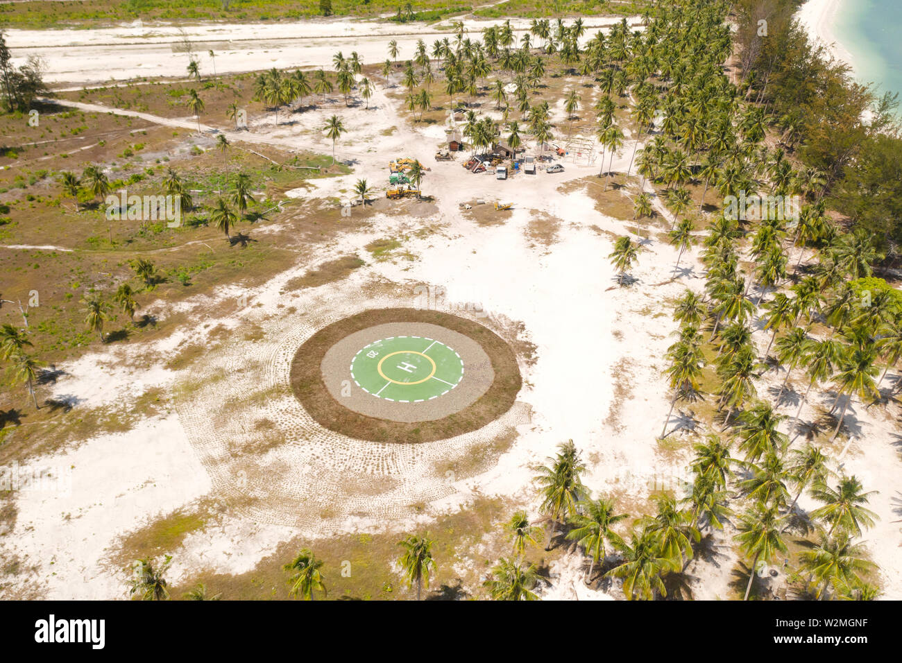 Hubschrauberlandeplatz auf einer tropischen Insel. Balabac, Palawan, Philippinen. Hubschrauberlandeplatz unter Palmen auf einer tropischen Insel, Ansicht von oben. Stockfoto