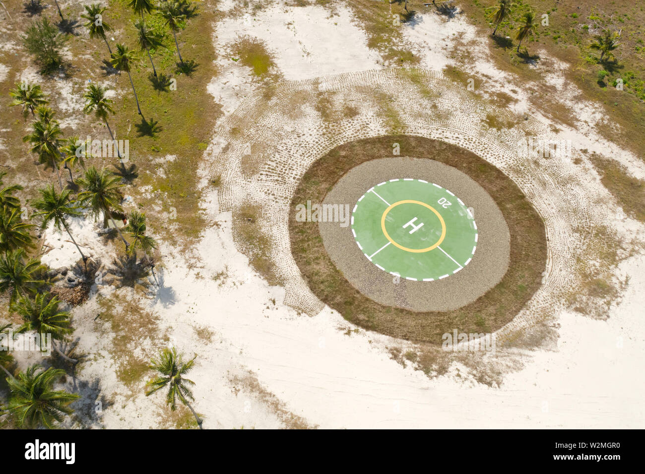 Hubschrauberlandeplatz auf einer tropischen Insel. Balabac, Palawan, Philippinen. Hubschrauberlandeplatz unter Palmen auf einer tropischen Insel, Ansicht von oben. Stockfoto