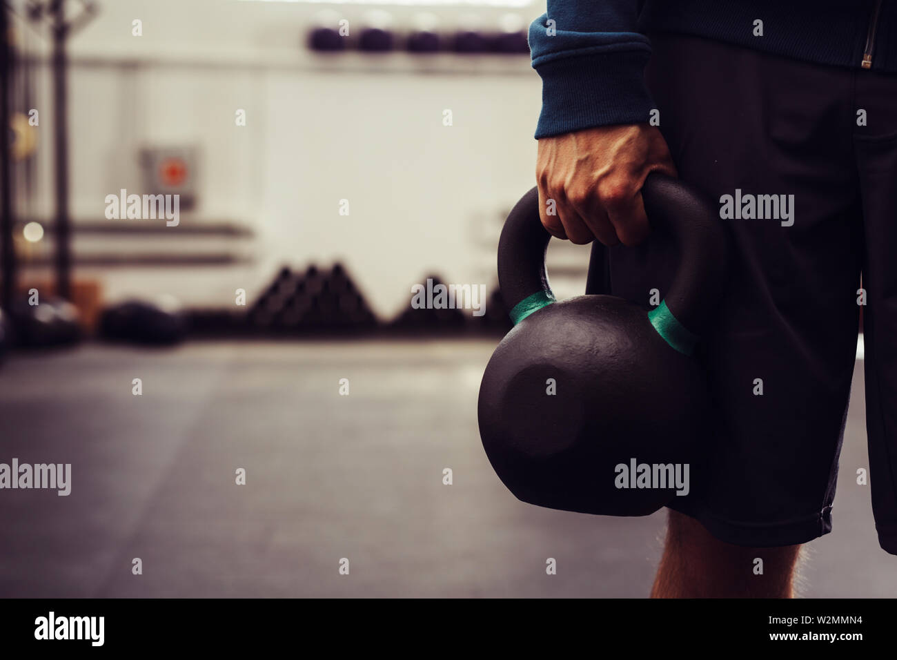 Nahaufnahme von Mann mit kettlebell im modernen Fitnessraum Stockfoto