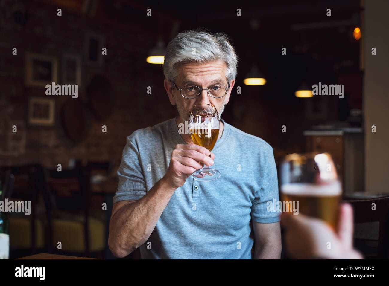 Nachdenklich, älterer Mann mit einem Bier in der Bar Stockfoto