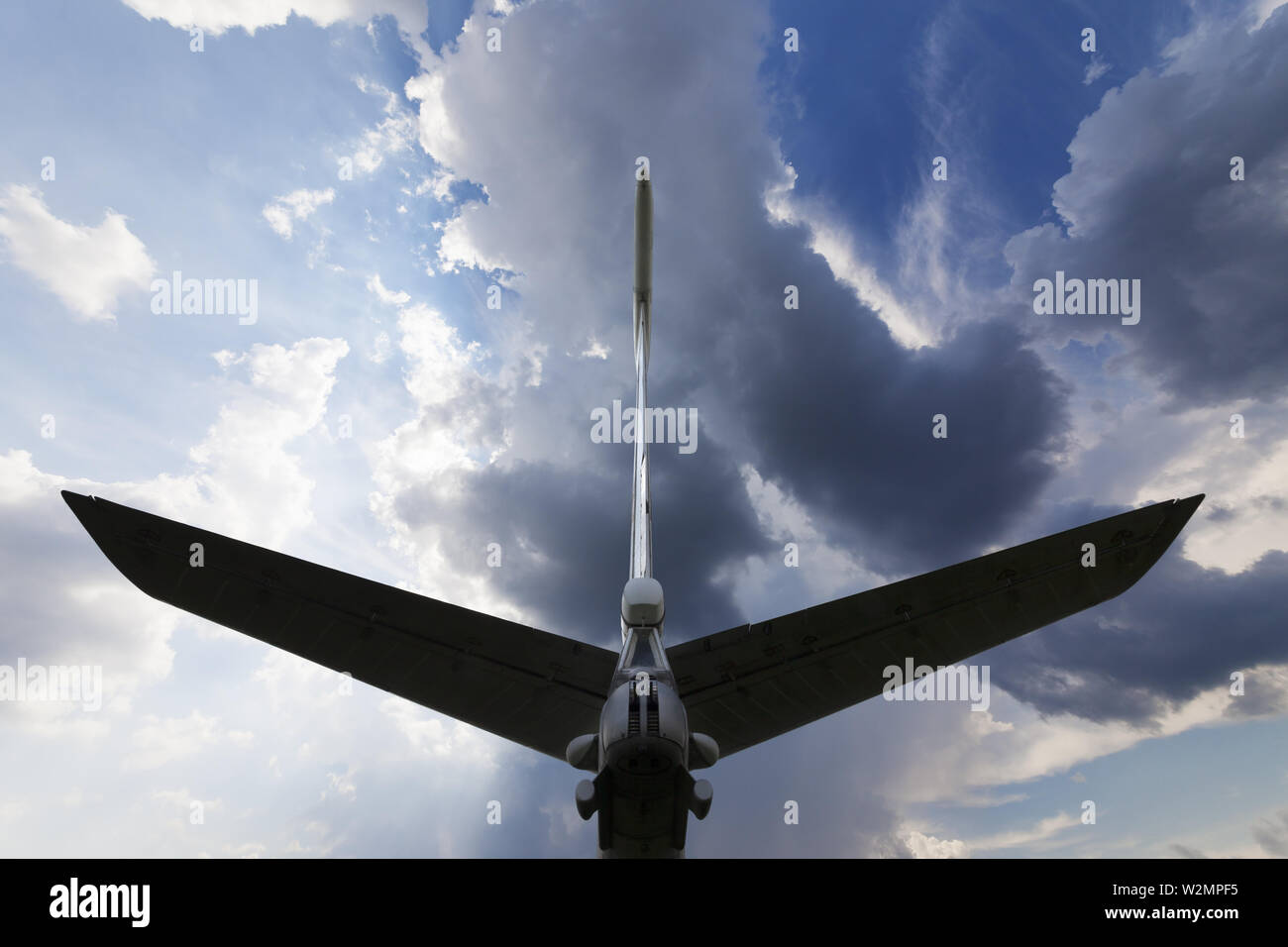 Silhouette von Flugzeugen Schwanz und sonnigen blauen Himmel mit Wolken in Abend. Ansicht von hinten. Stockfoto