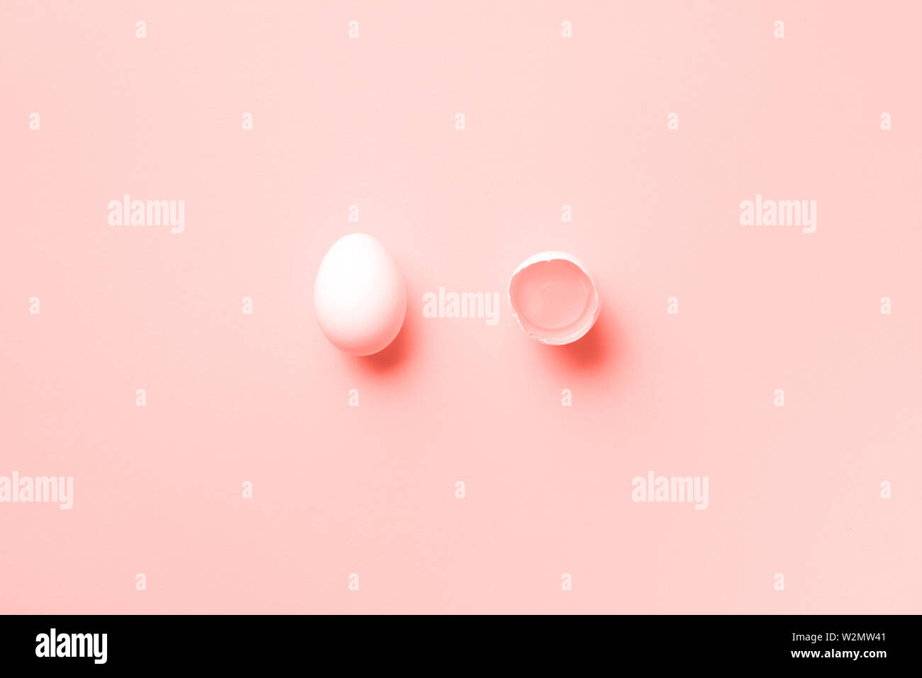 Essen Konzept mit weißen huhn eier auf trendige Coral Hintergrund. Ansicht von oben. Kreative Muster im minimalistischen Stil. Trendy coral Farbe des Jahres 2019. Wohnung La Stockfoto