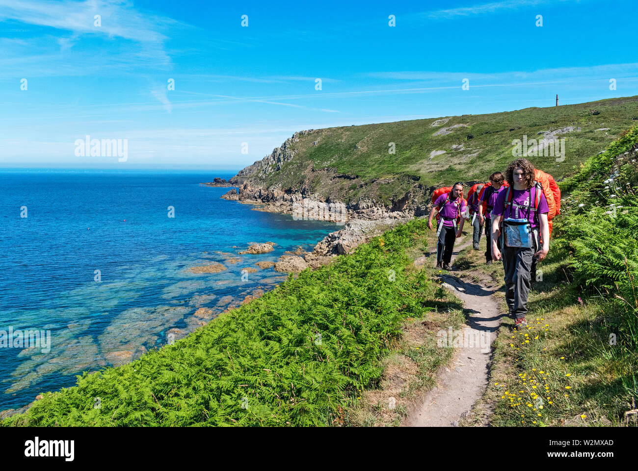 Teenage walking Gruppe im Südwesten coastl Pfad, West penwith, Cornwall, England, Großbritannien, Großbritannien. Stockfoto
