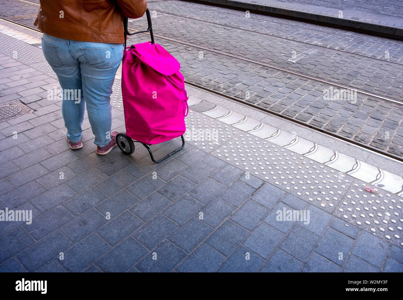Nicht erkennbare übergewichtige Frau mit Einkaufswagen auf der Straße Stockfoto