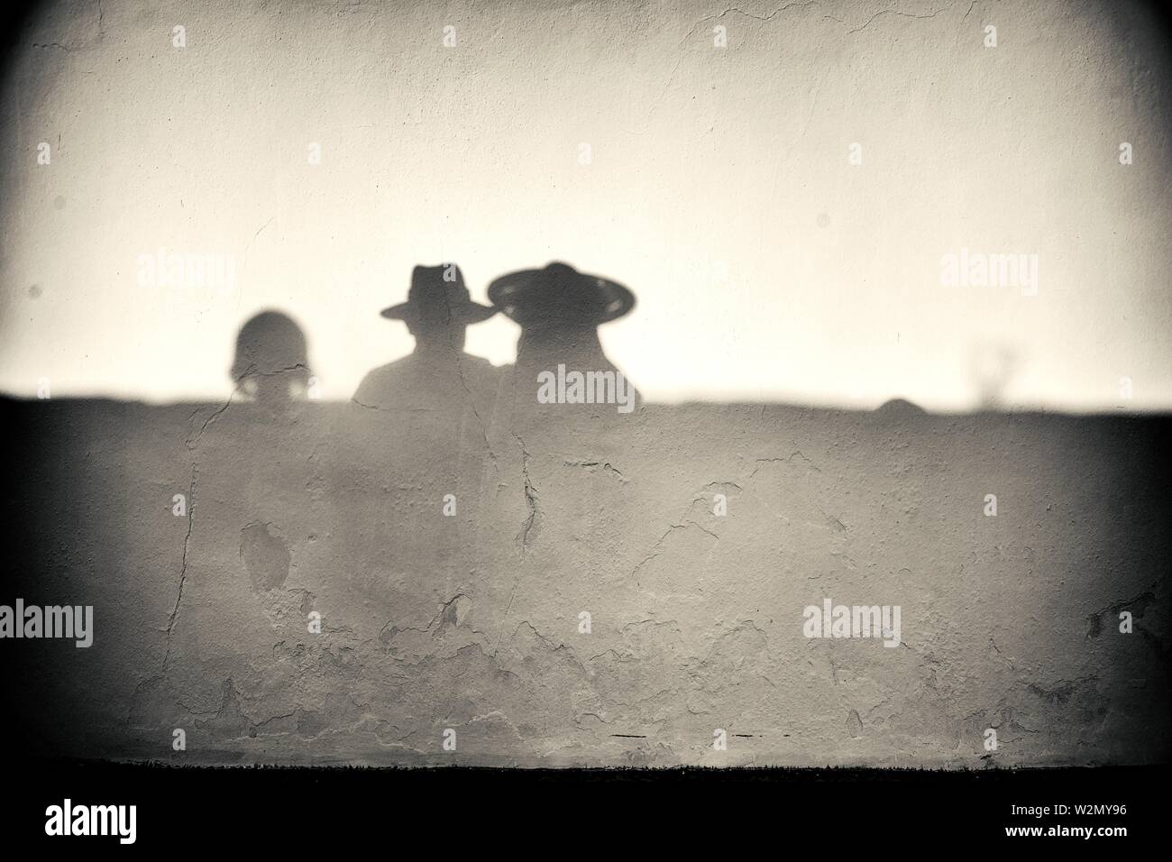 Silhouette der eine nicht erkennbare Mann und Frau mit Strohhut auf einer Wand reflektiert. Mahon, Balearen, Spanien, Europa. Stockfoto