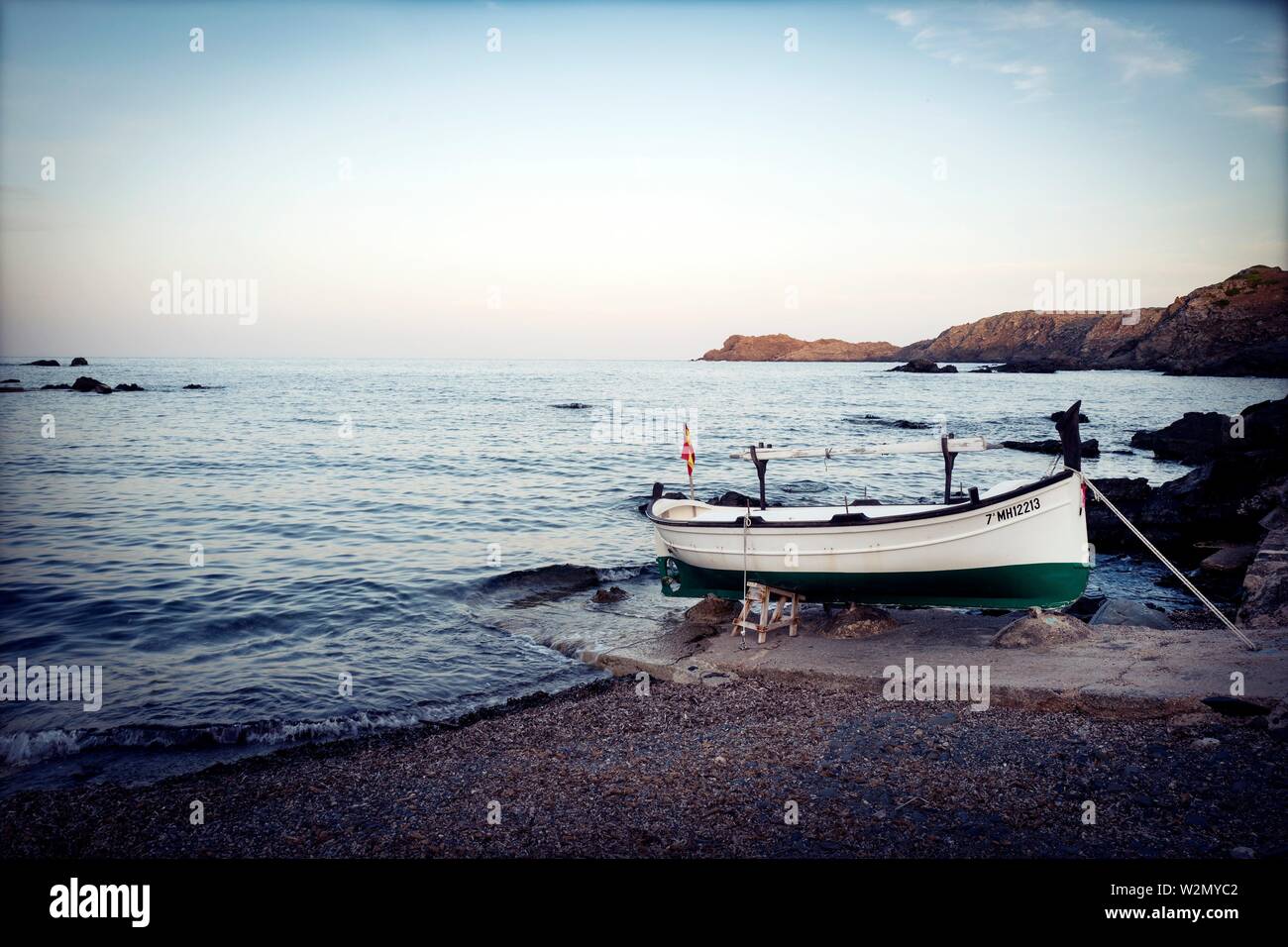 Typisch mediterranes Dorf mit einer Menorquinischen Boot im Vordergrund. Cala des Murtar, Menorca, Balearen, Spanien. Stockfoto