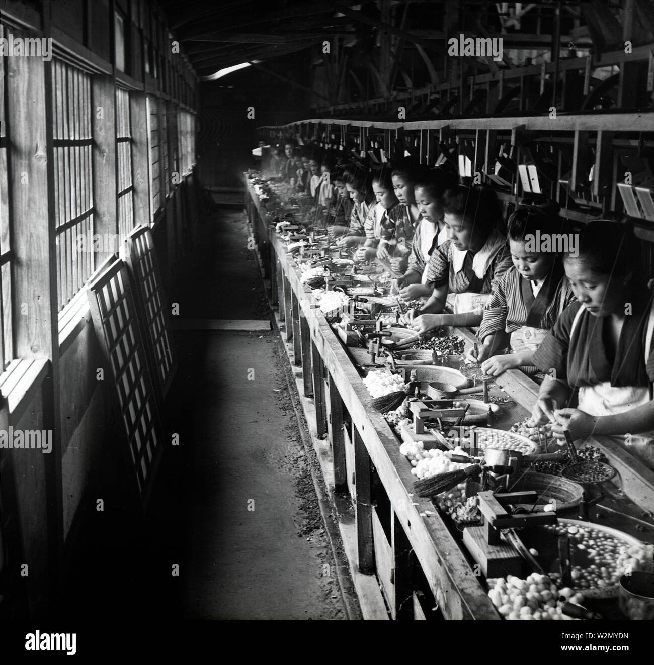 [1900s Japan - Japanische Frauen Reeling Silk] - Kochen Kokons und reeling Silk bei einer seidenfabrik. 20. Jahrhundert vintage Glas schieben. Stockfoto