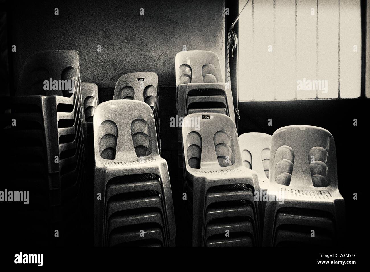 Stühle gestapelt in einem Zimmer in der Nähe von einem Fenster. Falset, Tarragona, Katalonien, Spanien, Europa. Stockfoto