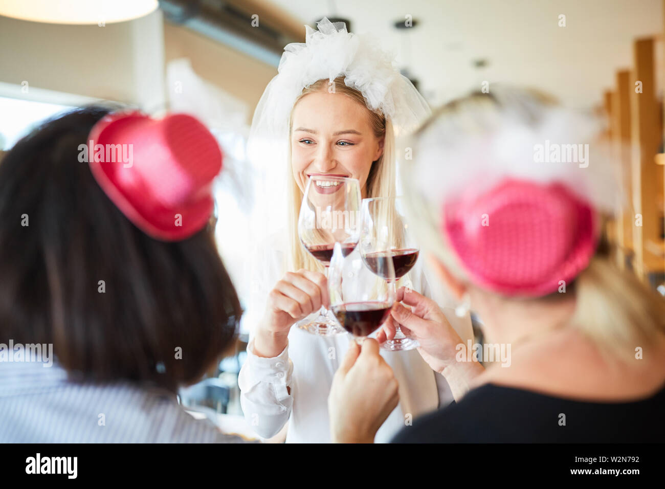 Braut und Freunde feiern Polterabend mit Rotwein im Restaurant Stockfoto